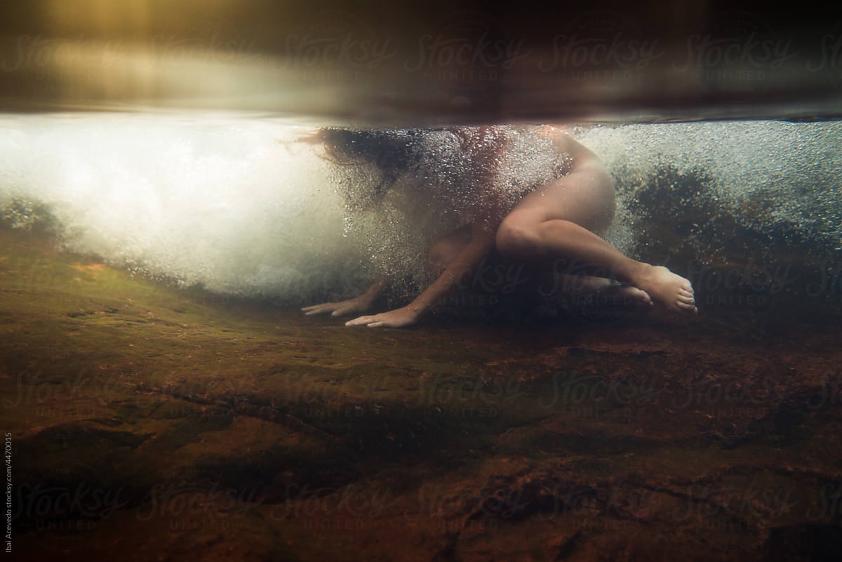 Underwater woman fighting against river stream