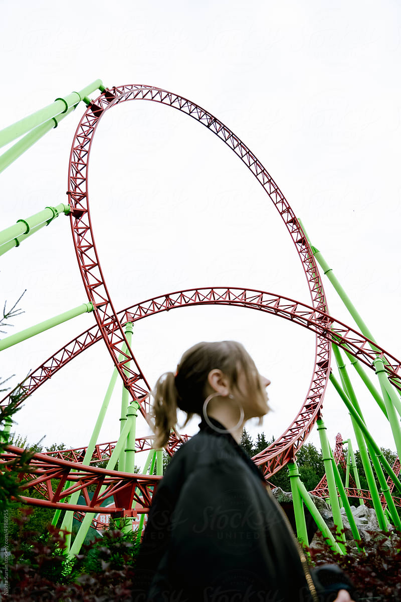 Beautiful girl on a background of a roller coaster