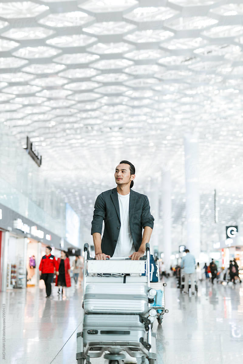 Man pushing luggage through an airport