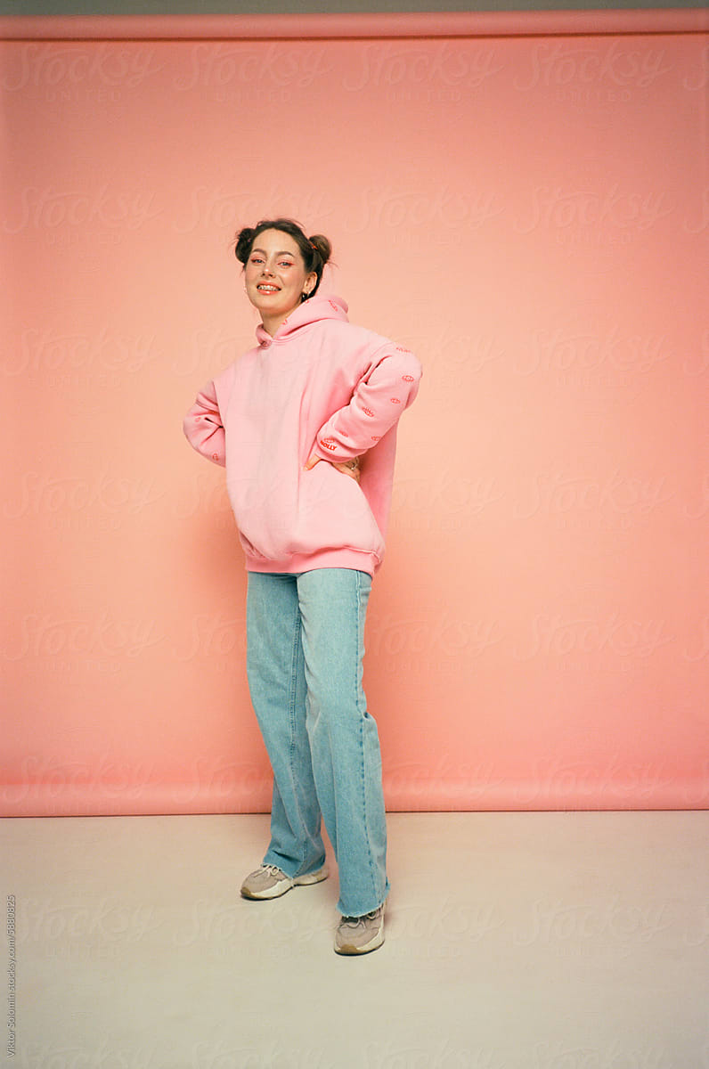 Happy woman in casual outfit on peachy pink background