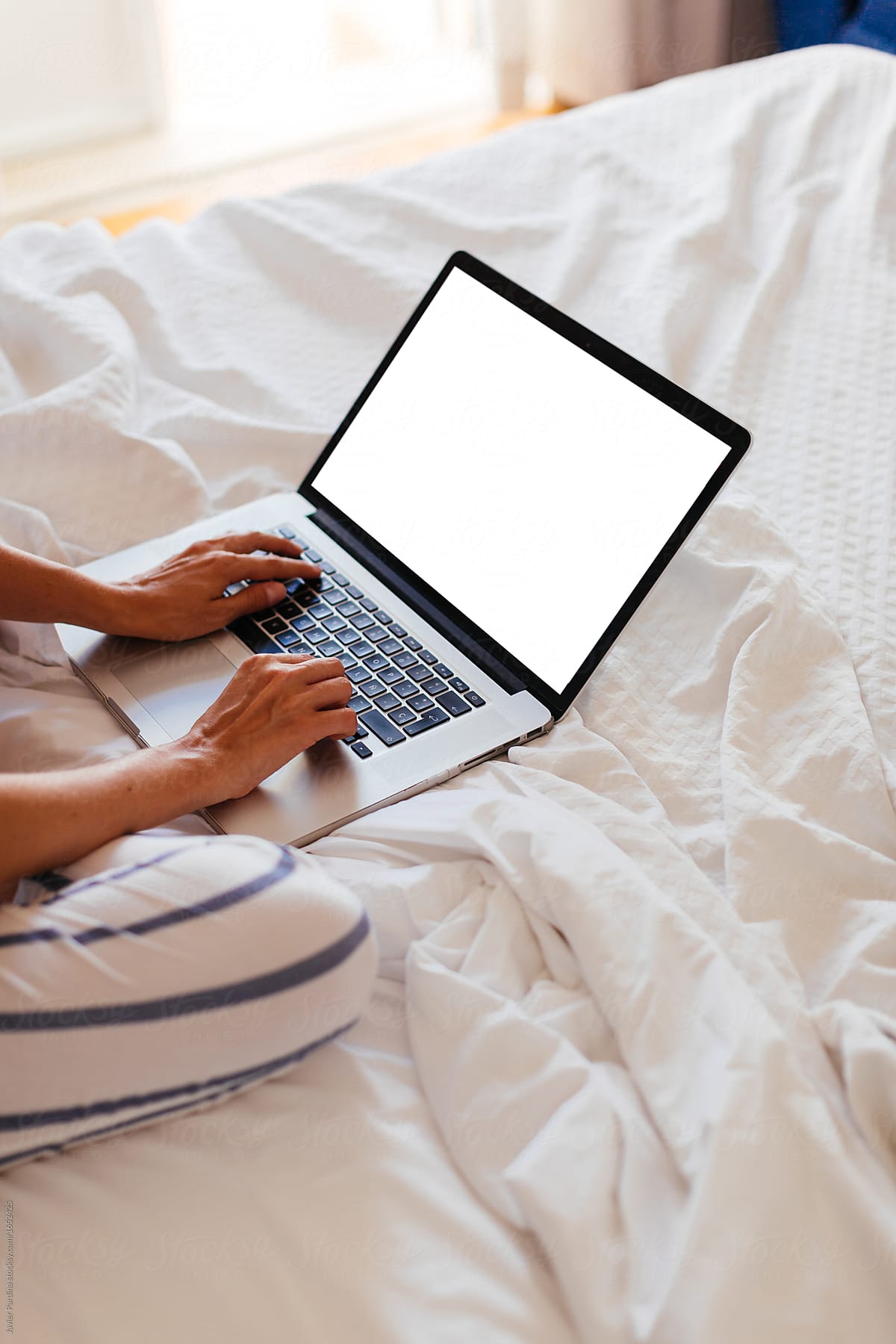 Woman working  with laptop on the bed