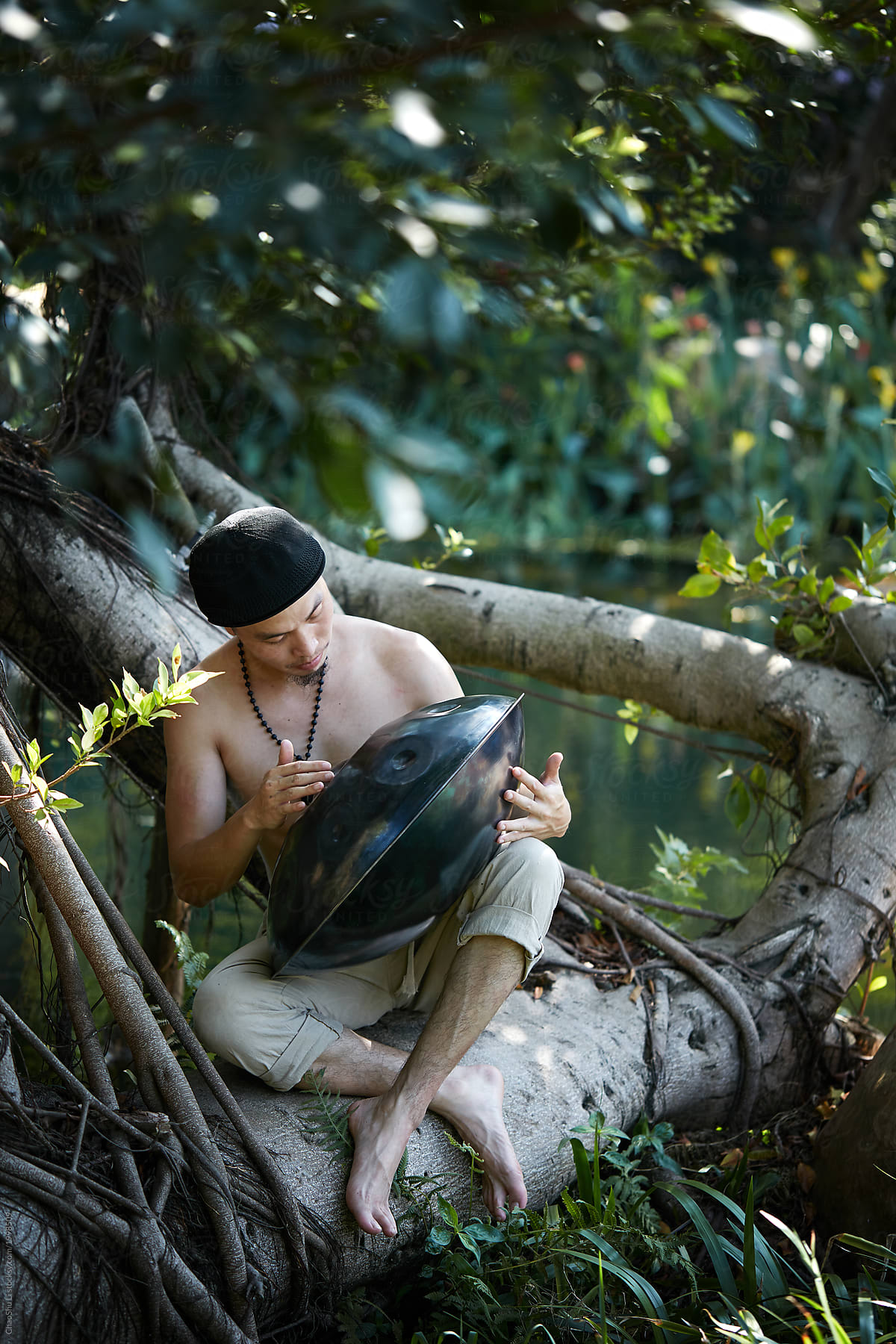 Asian Man Playing Hang Drum In The Park, Closeup by Stocksy Contributor  ChaoShu Li - Stocksy