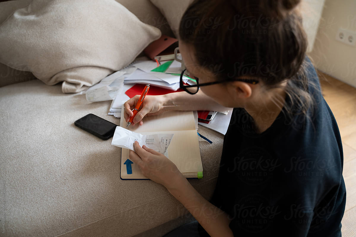 woman reviewing, organizing receipts, invoices, filling out tax forms