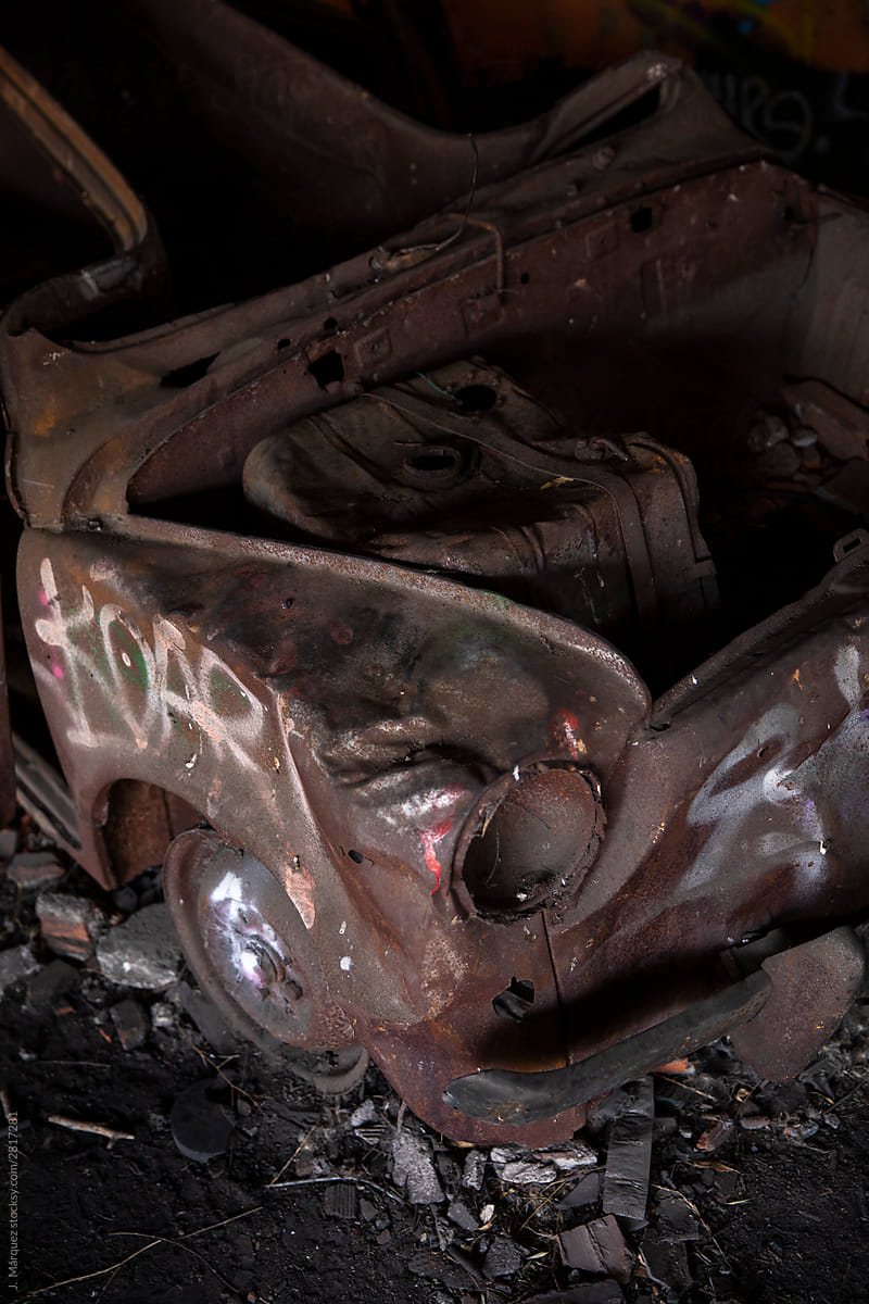 Rusty car with graffiti on scrapyard