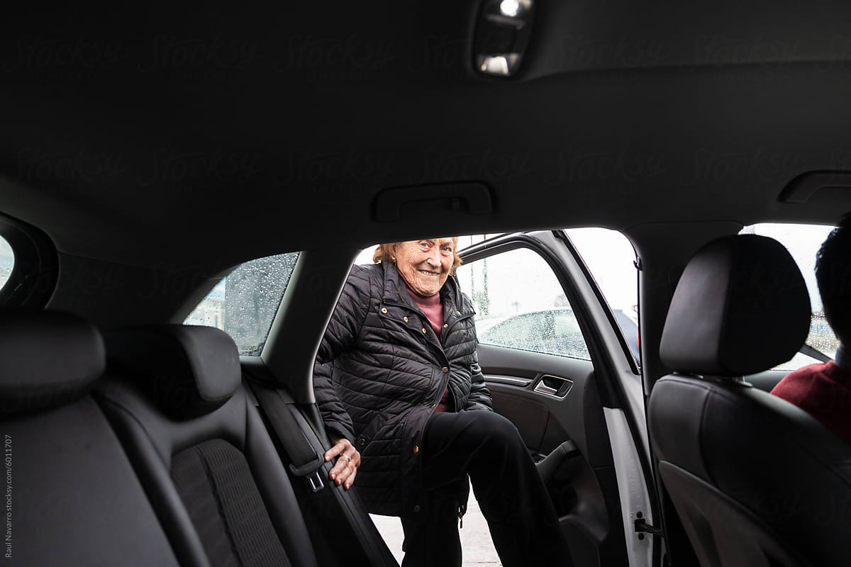 Senior woman smiling as she exits car