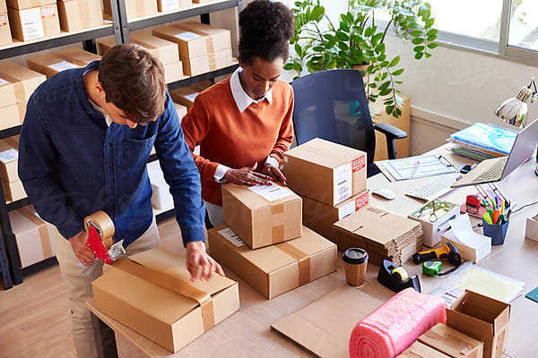 Young Logistic Manager Organizing Boxes In Storage by Stocksy