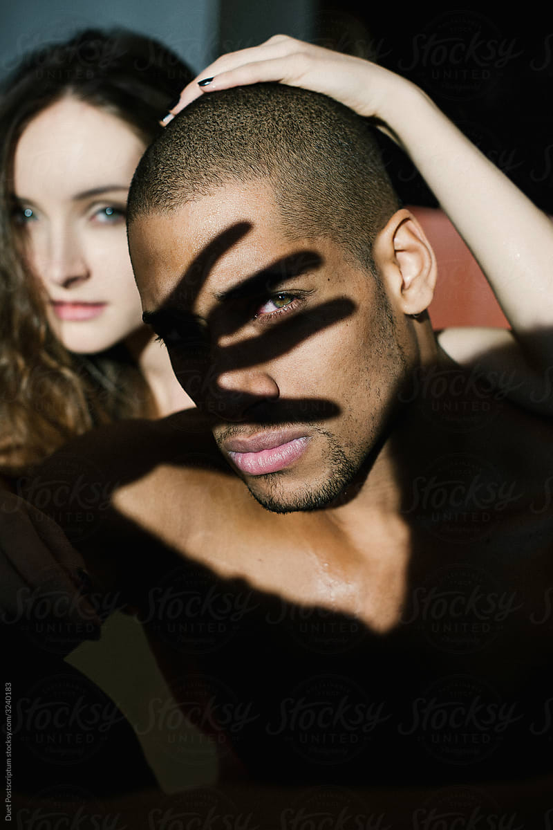 Portrait of black man with white girl on the background.