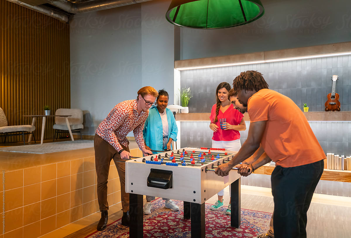 People Playing Table Football Game At Co-working