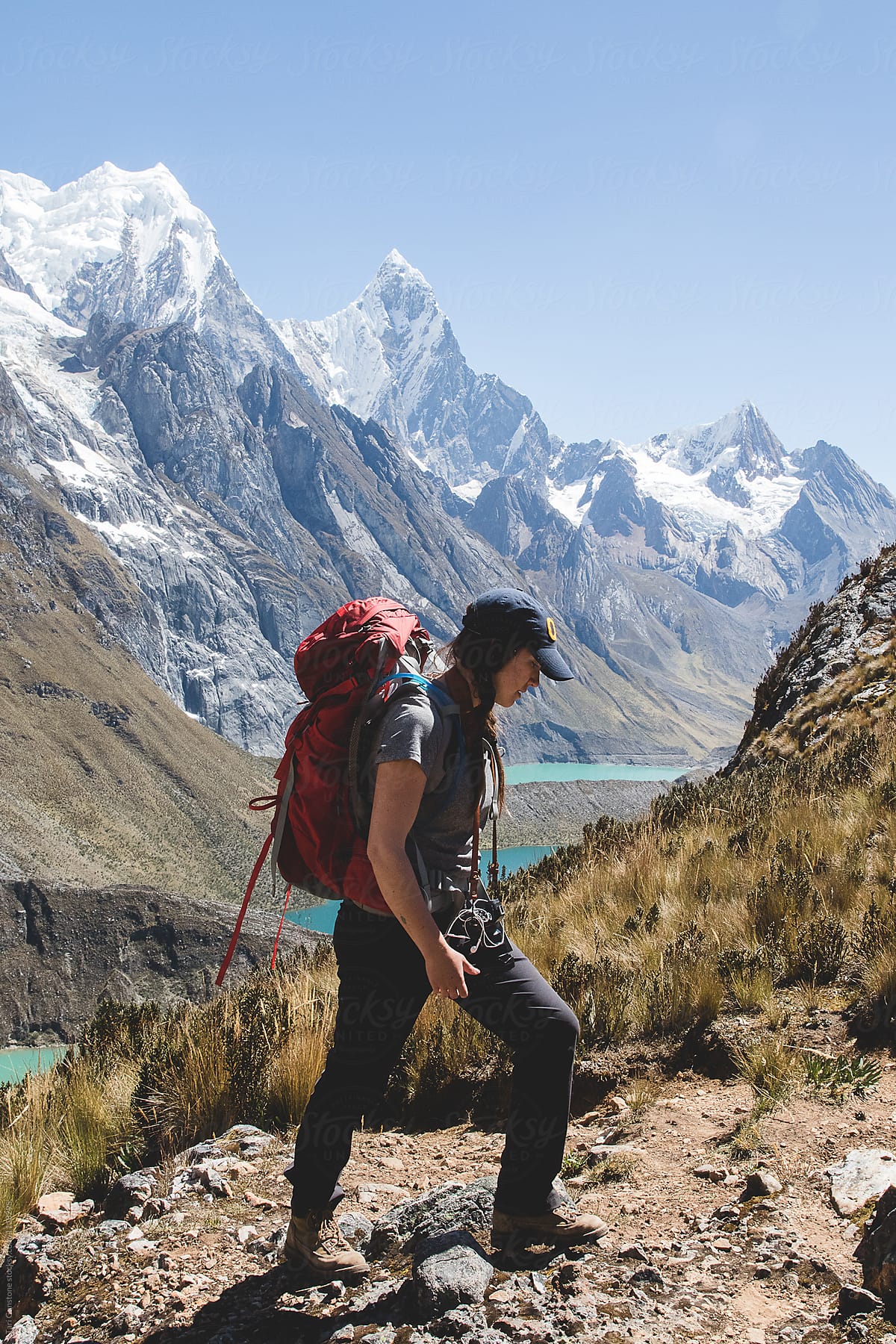 Backpacker hikes onward with rugged scenery in background