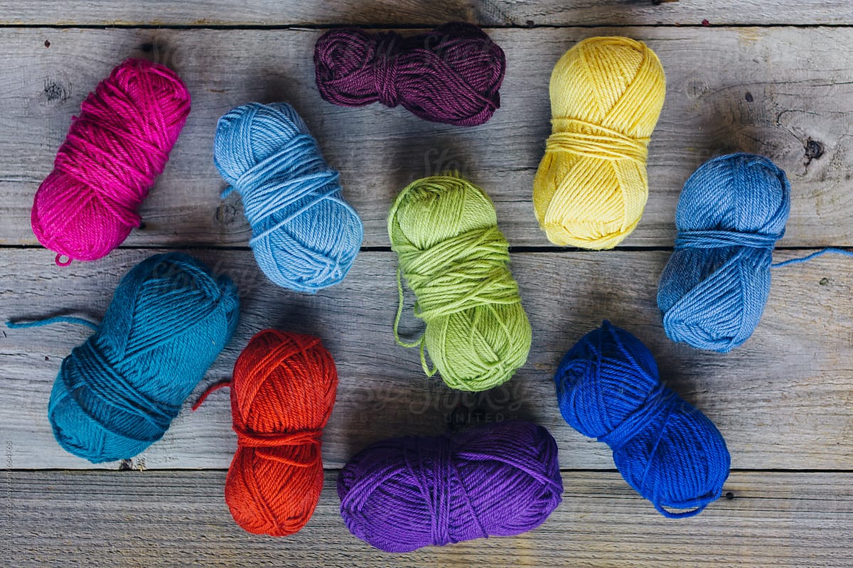 A selection of colourful wool on a wood background