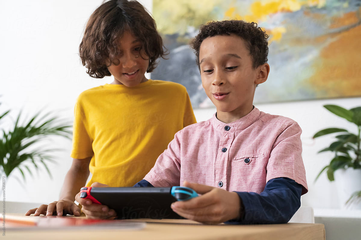 Black boys using gadget playing video game