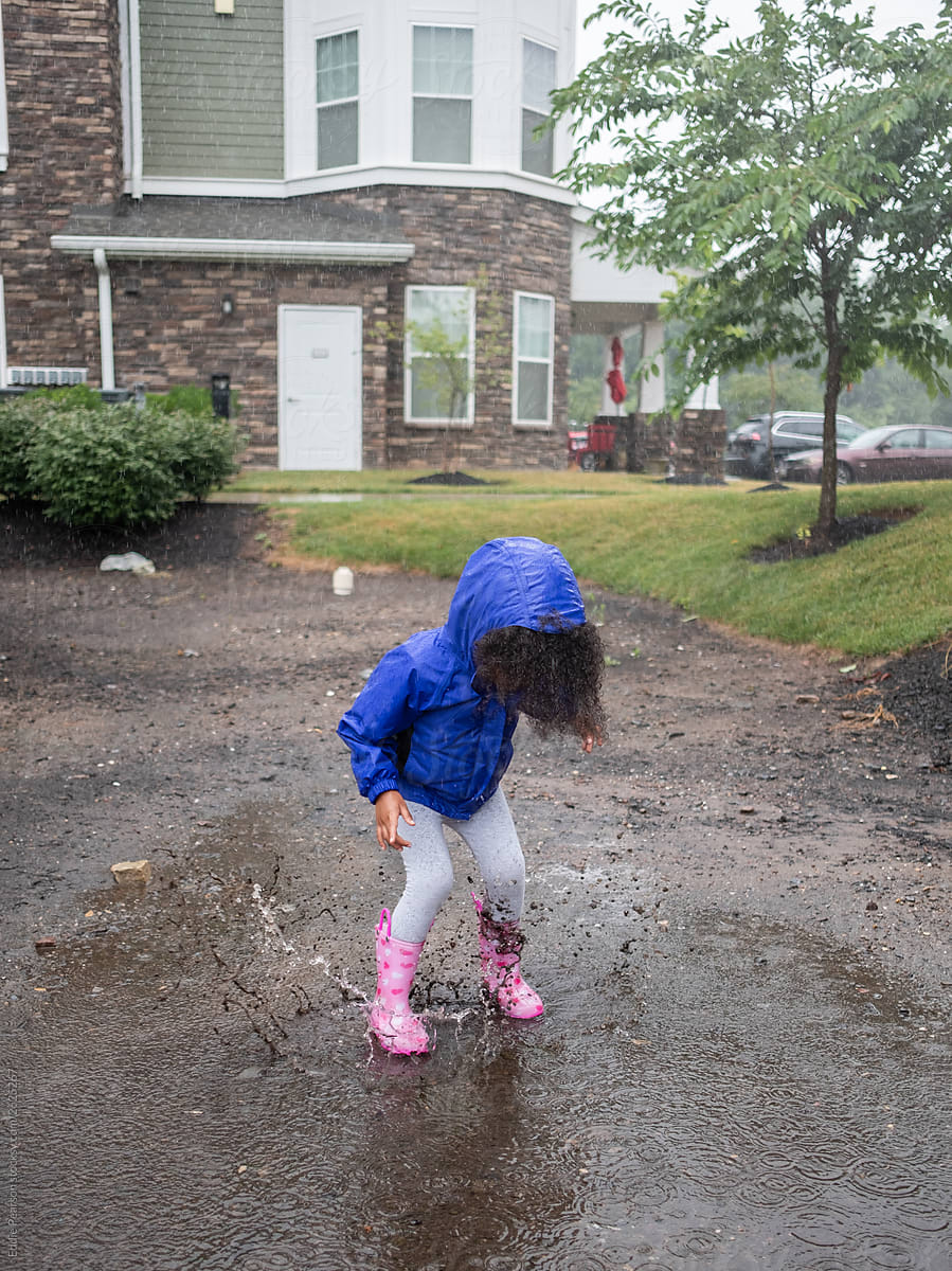 Toddler jumping in puddles