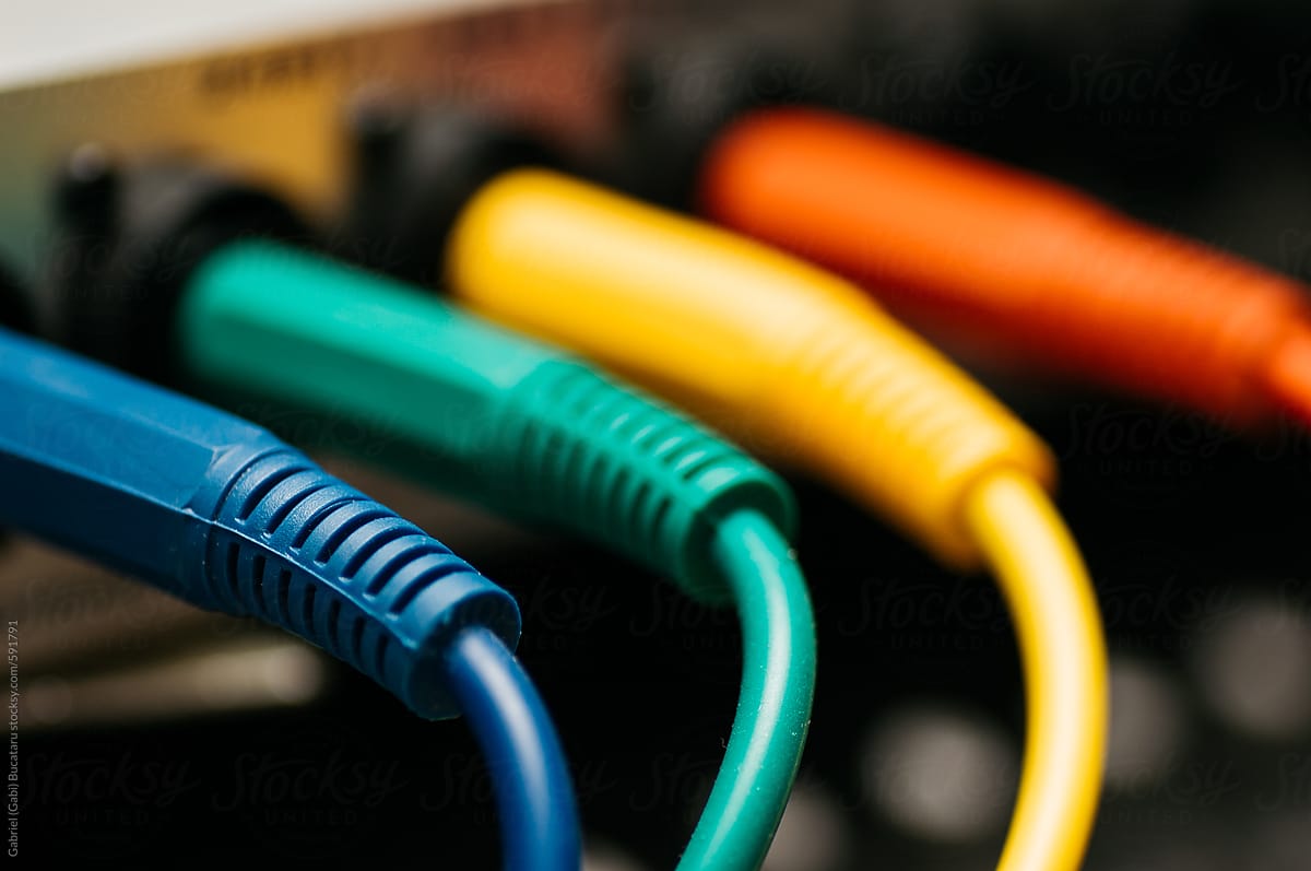 Various colored plugs connected into an audio device