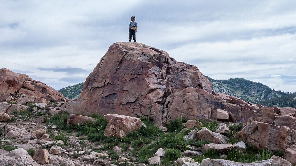 Small boy standing on a large boulder