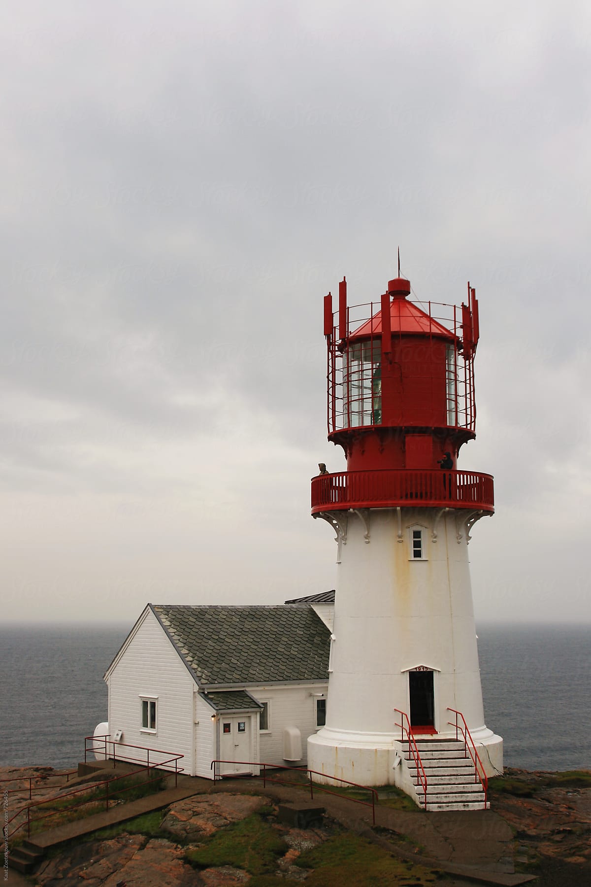 Lindesnes Fyr, Norway, a red and white lighthouse with the misty sea in the background.