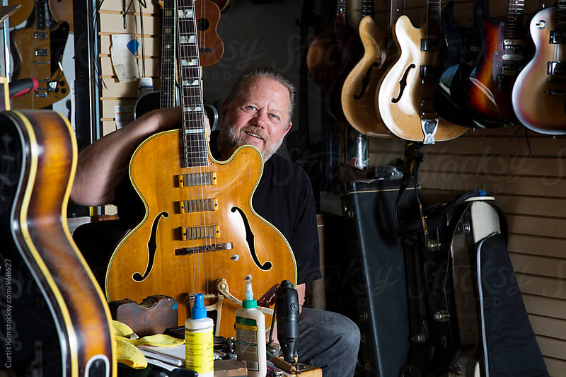 Music store owner next to his instruments