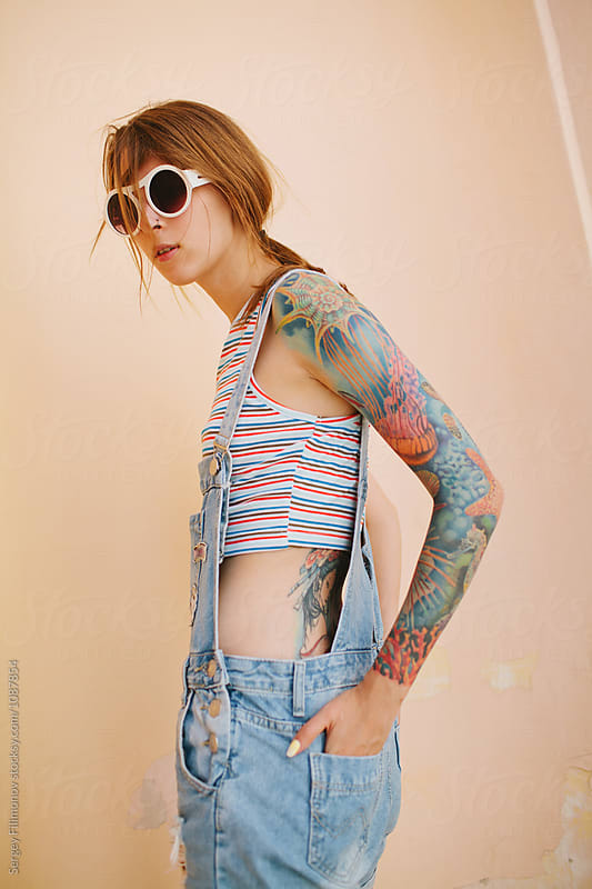beautiful fashionable tattooed girl with a simple background