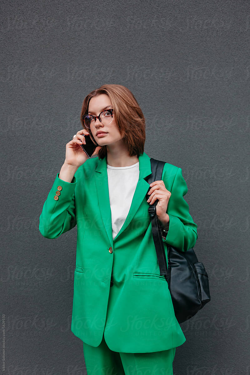 Young woman in elegant suit talking on mobile phone