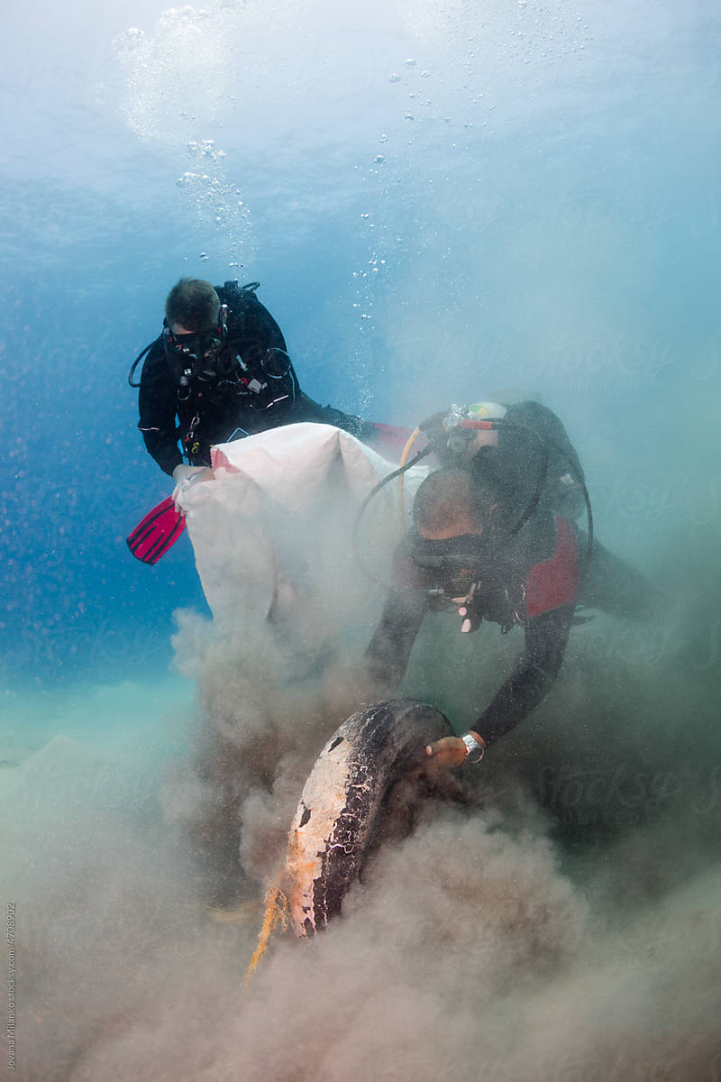 Scuba Divers Pulling Tire Trash Out of the Sea
