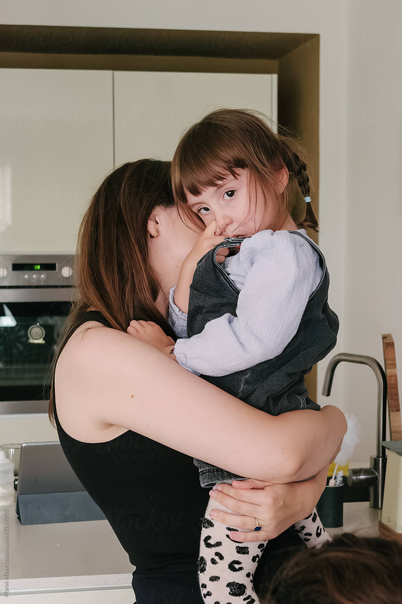 Mother holding daughter in kitchen