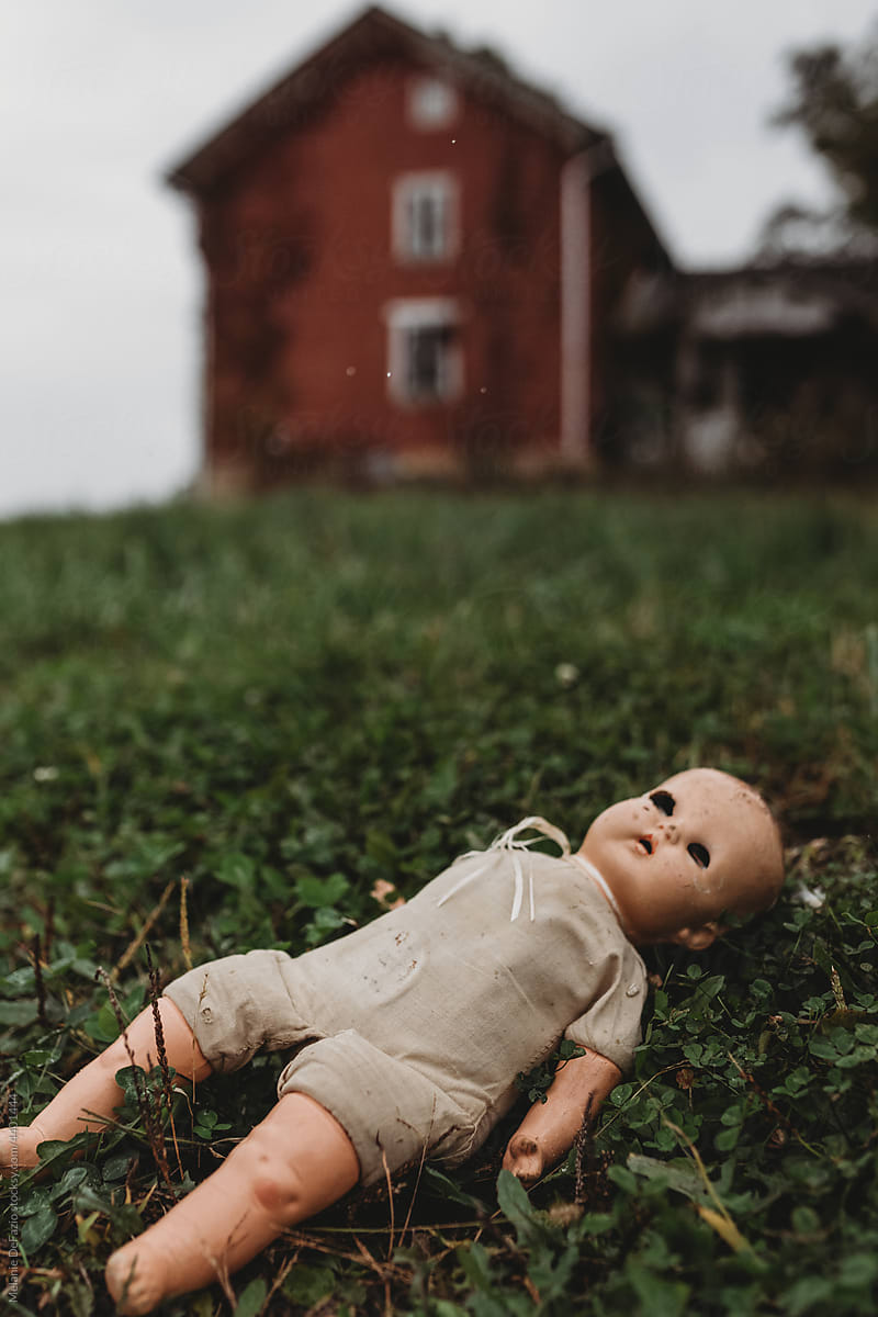 Creepy baby doll in the grass
