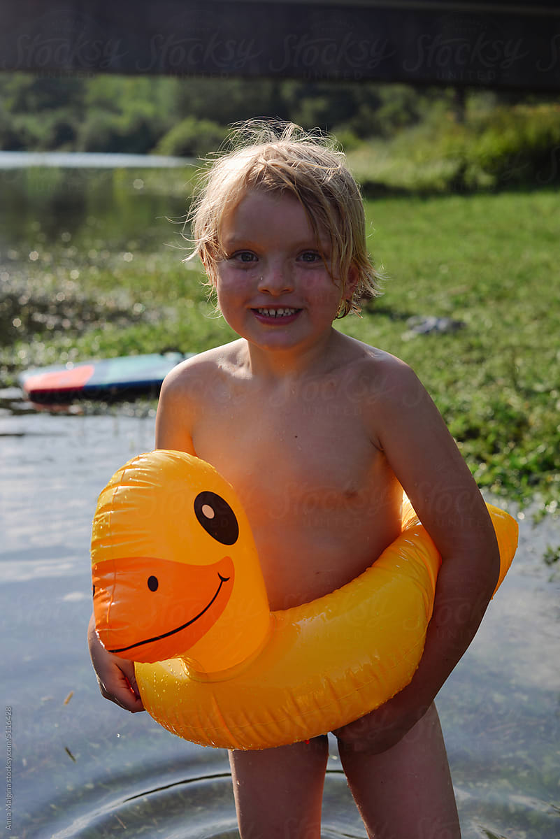 A happy kid with a yellow duck in water