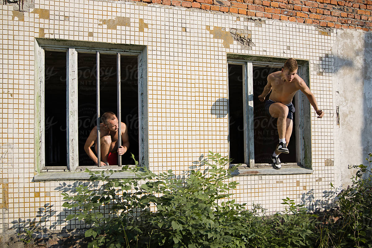 Male friends jumping out from windows