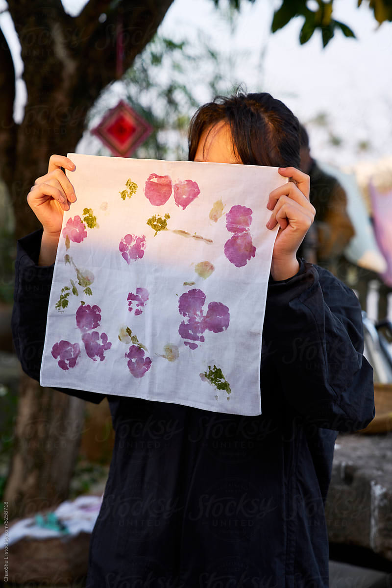 Asian girl is holding plant-dyed cloth works to dry
