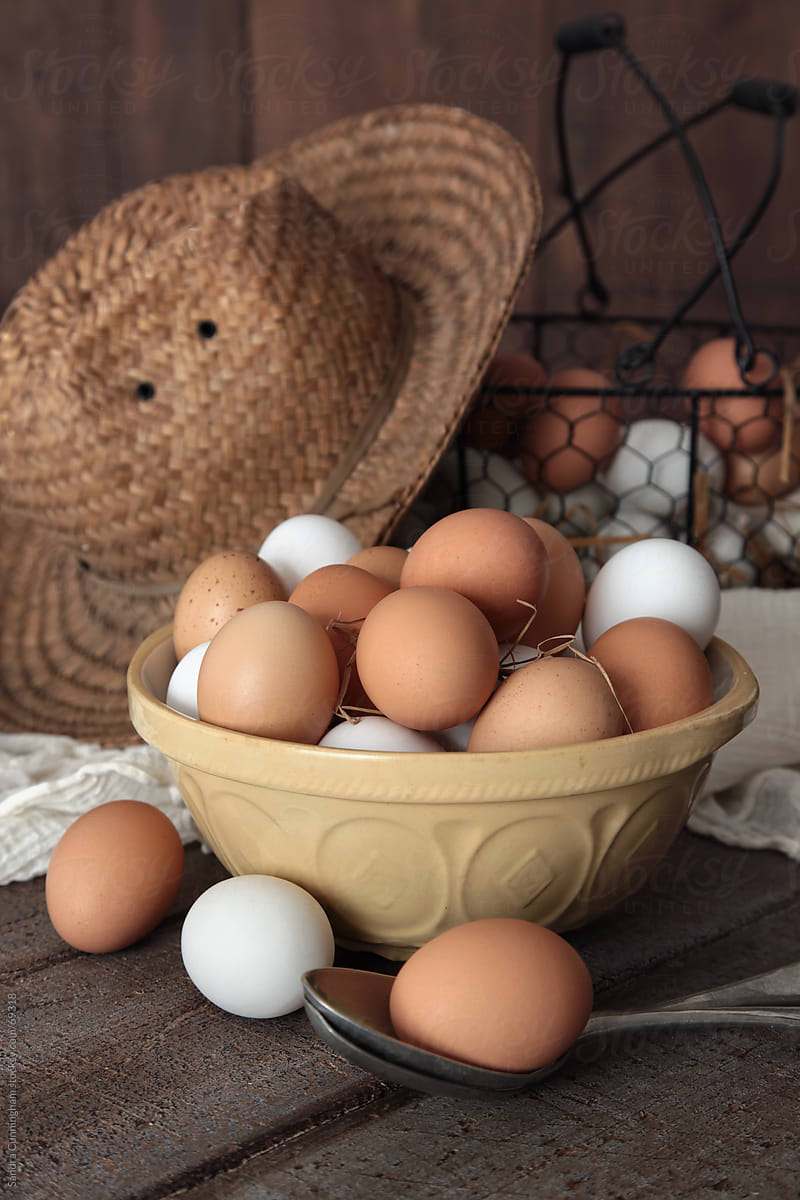 Bowl of brown and white eggs on country table