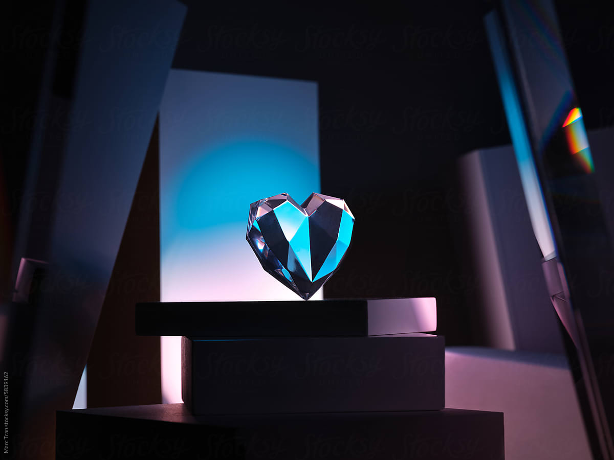 Crystal heart shape love symbol on podium on dark background.