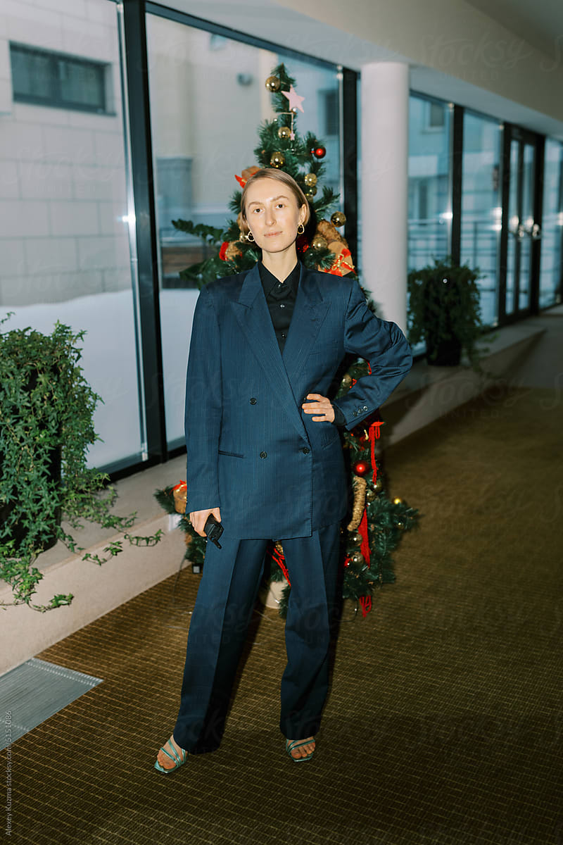 Business woman wearing man classic suite in front of  christmas tree