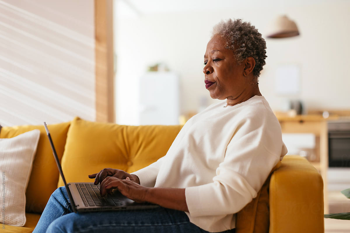 Concentrated senior woman using laptop at home