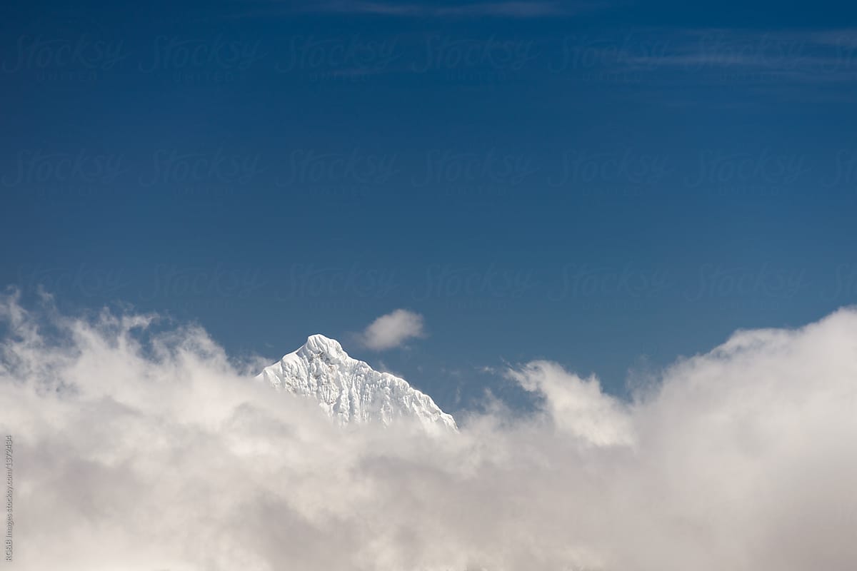 Mountain peak seen beyond soft clouds