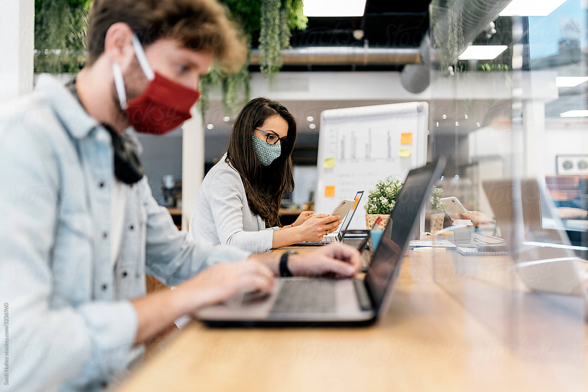 Portrait of Office Workers At Desk Wearing Face Masks