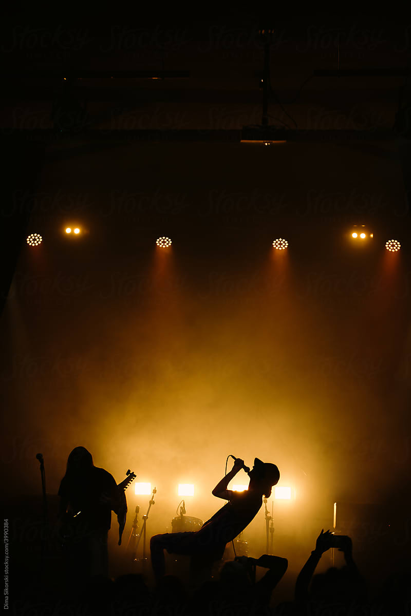 Epic silhouette of a rock singer in the light of concert spotlights