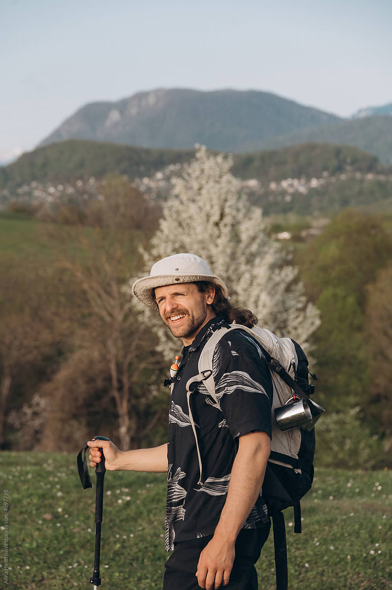 Cheerful hiker against hills and mountains