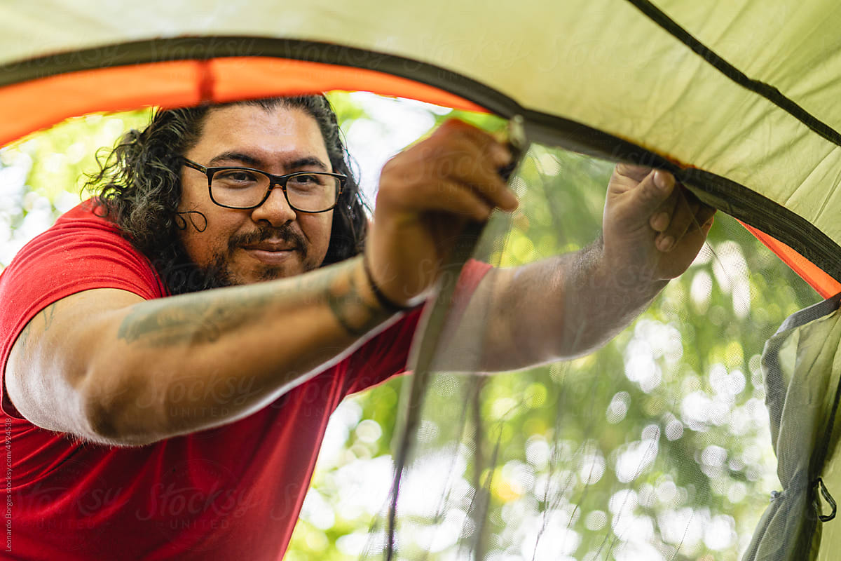Man closing camping tent