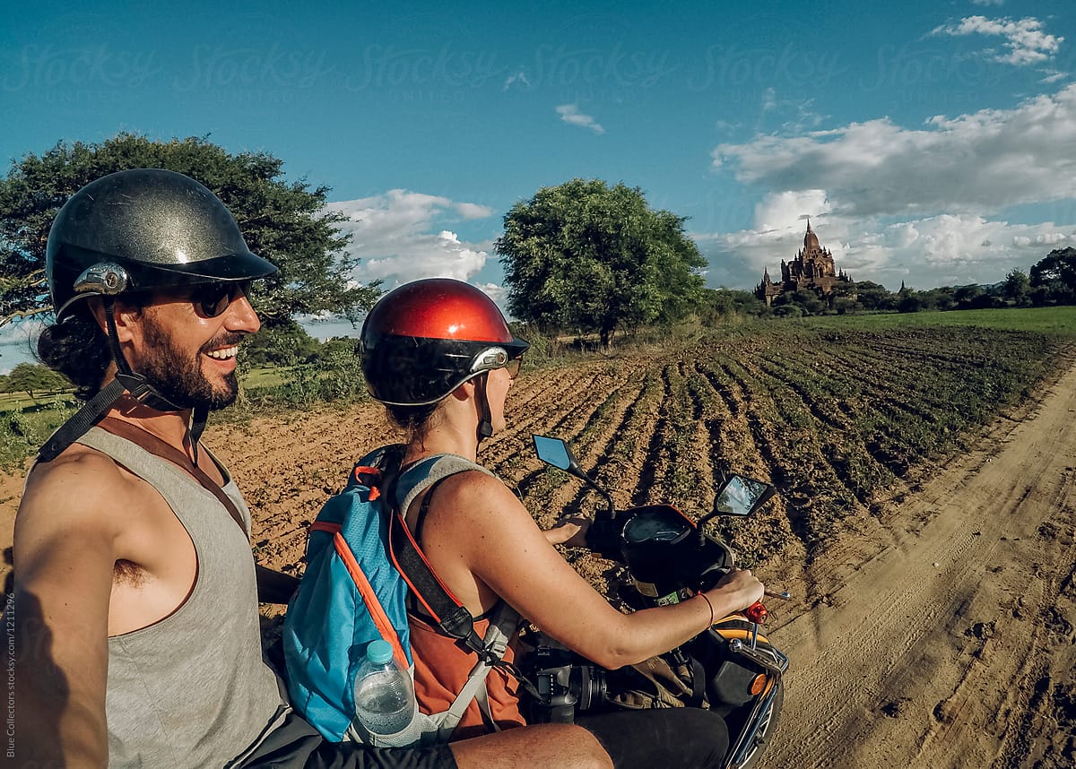 Happy couple on a motorbike traveling across Bagan temples and taking a selfie