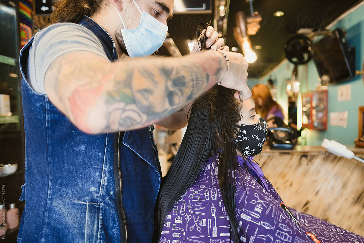 Stylist cutting young girl’s hair at a salon