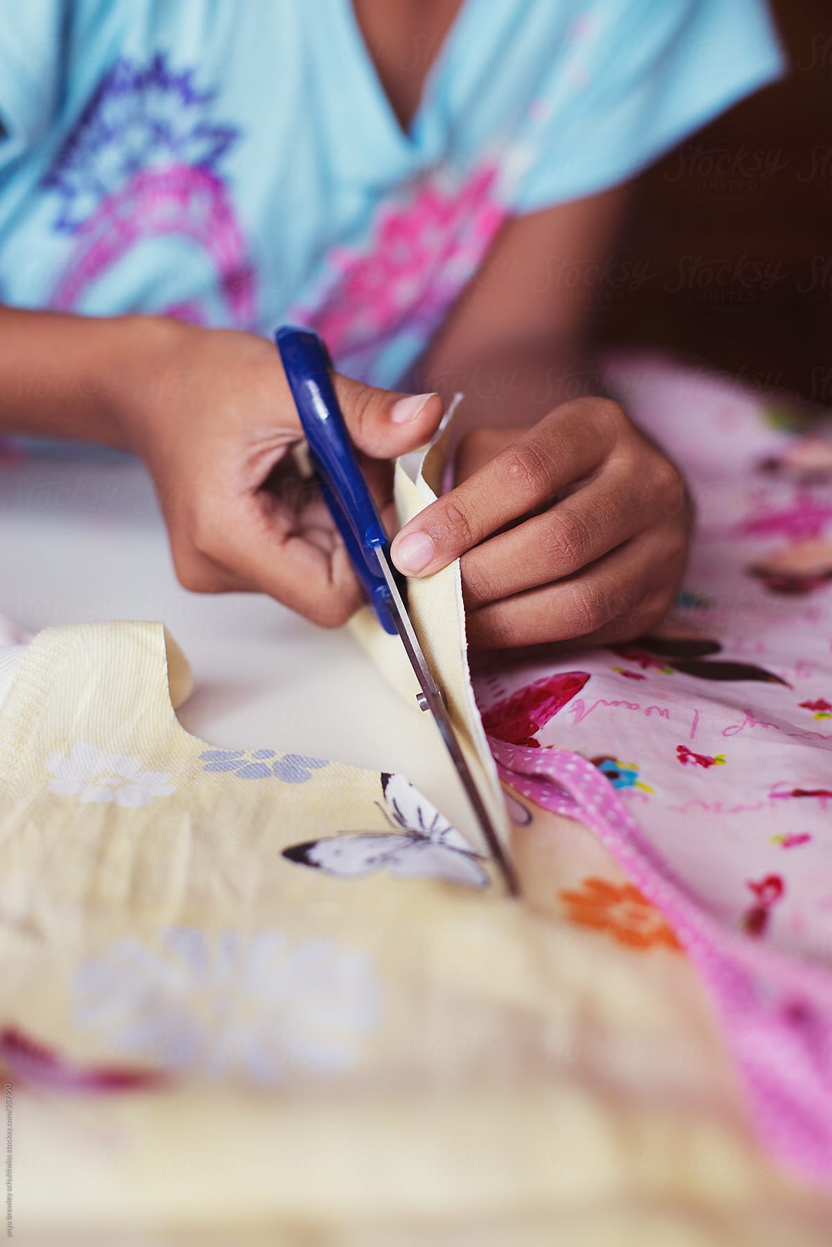 Closeup of a  child using a scissors to cut fabric