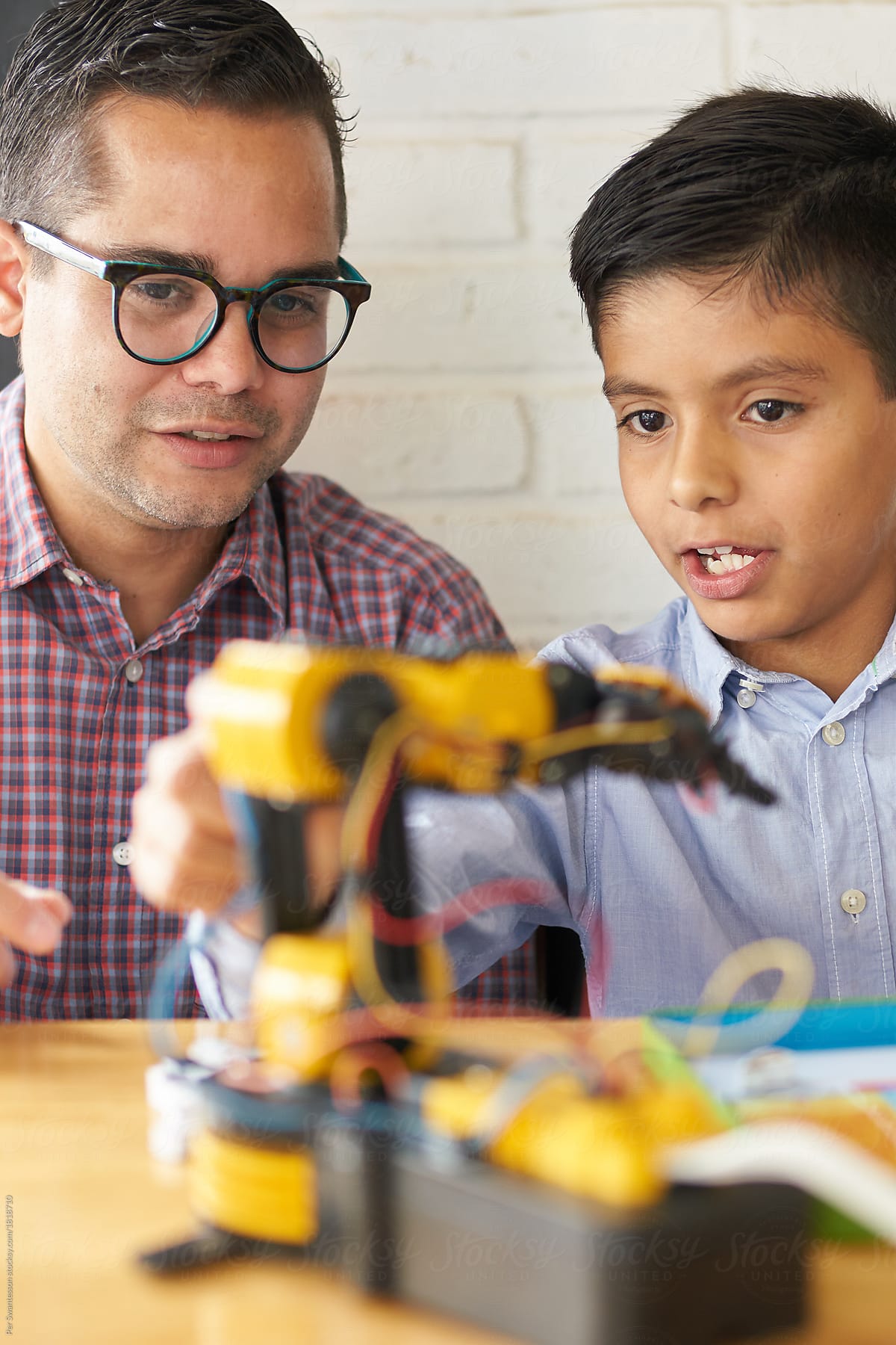 Man and young boy educating themselves in robotics