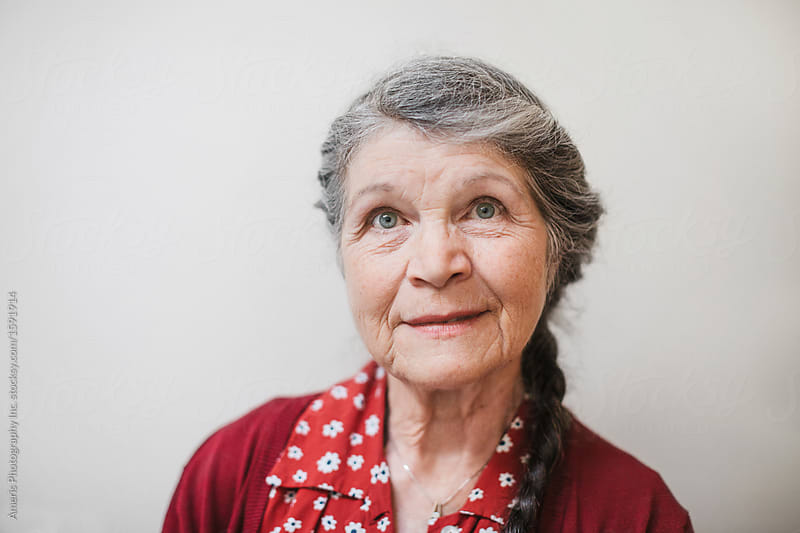 Portrait of content senior woman on plain white background