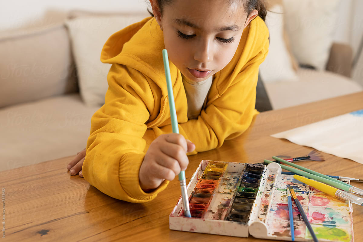 Creative Inspiration. Girl in Yellow Hoodie Painting with Watercolors.