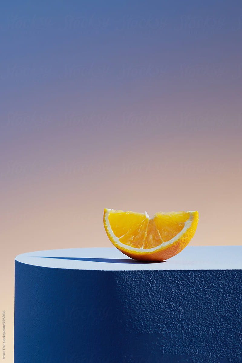 Orange fruit slice on blue podium