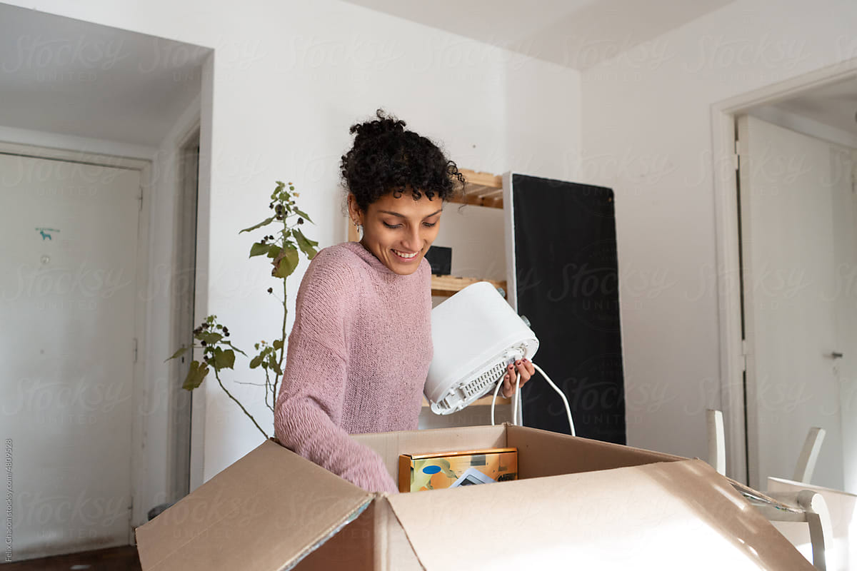 Young Woman Opening Boxes In A Moving
