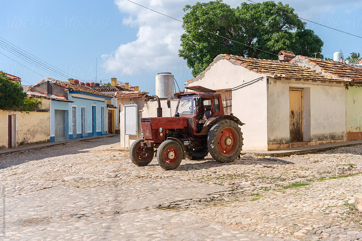 A Red Tractor Parked On A Cobbled Street