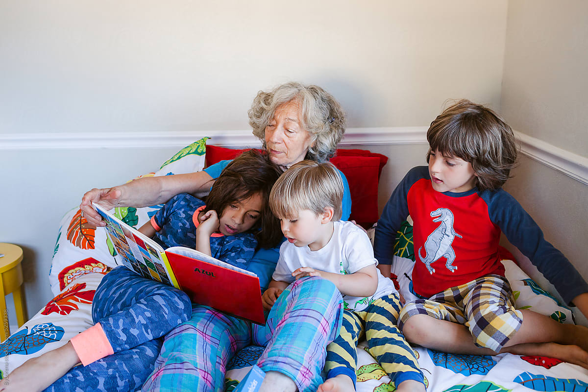 Grandmother storytelling grandsons in bed