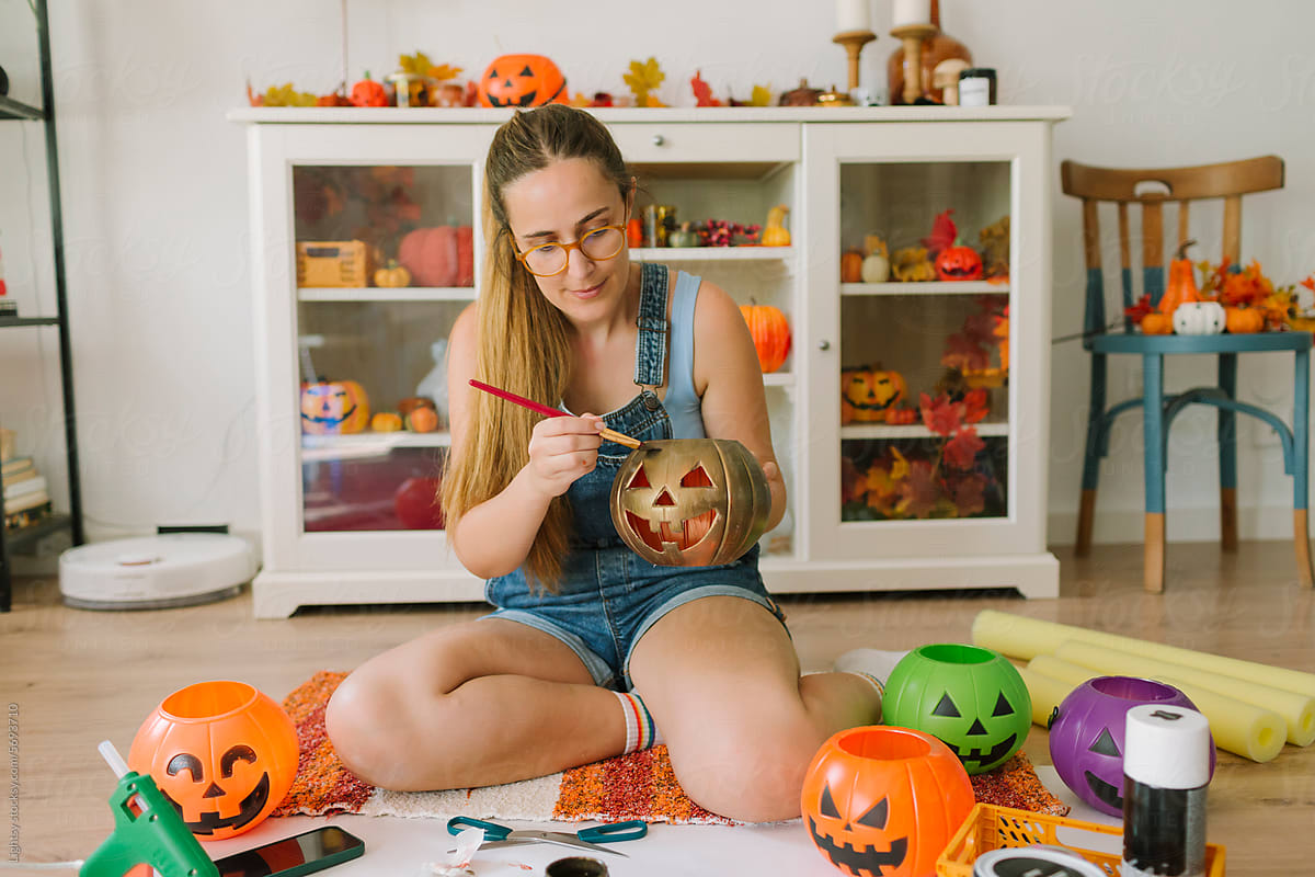 Woman painting pumpkins for Halloween