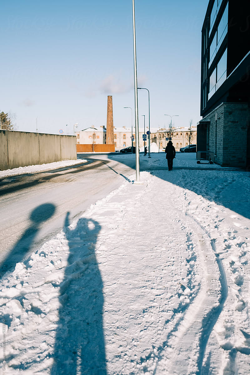 Shadow of a person waving hello in the snow