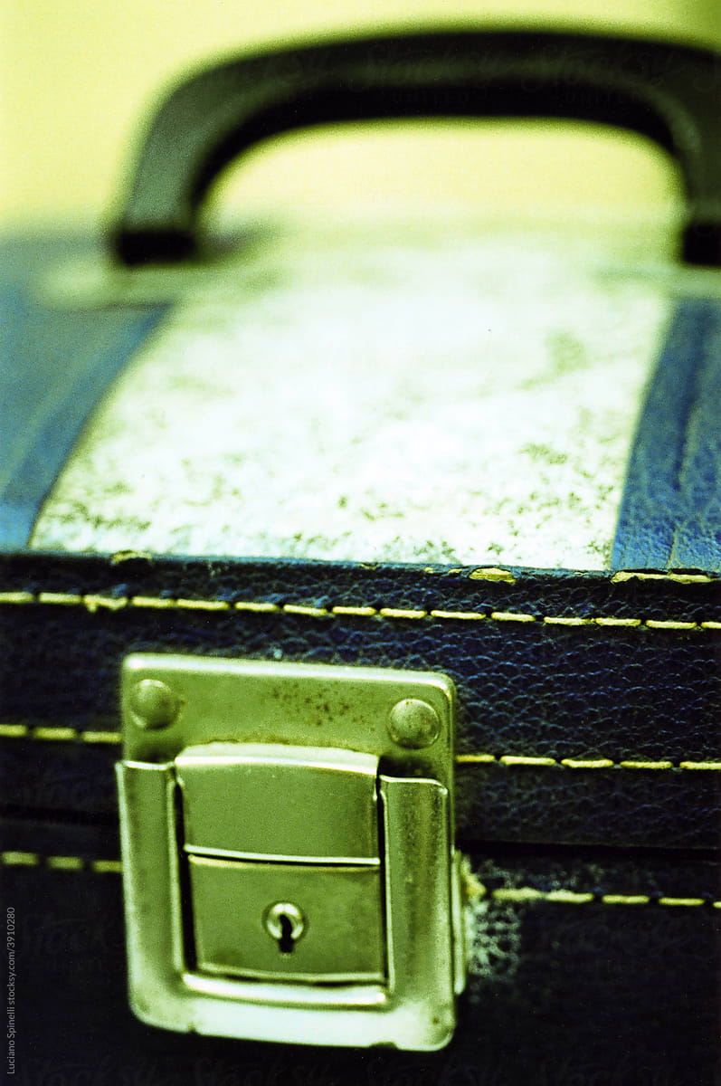 Close up photo of a metal lock of a leather chest with contrast seam